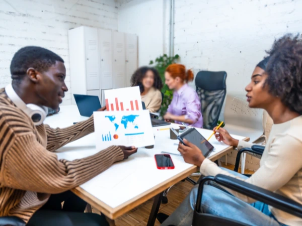 Professionals in a corporate training session discussing strategy around a table. Courses