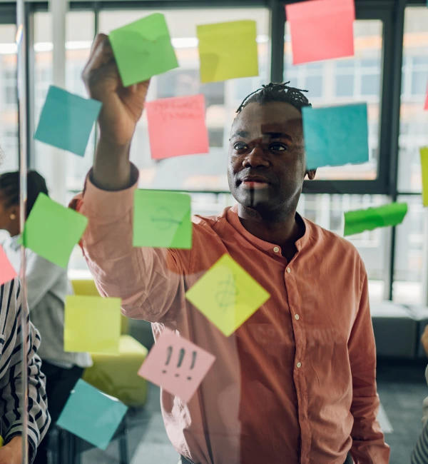 Business team using sticky notes on a scrum board during agile transformation workshop